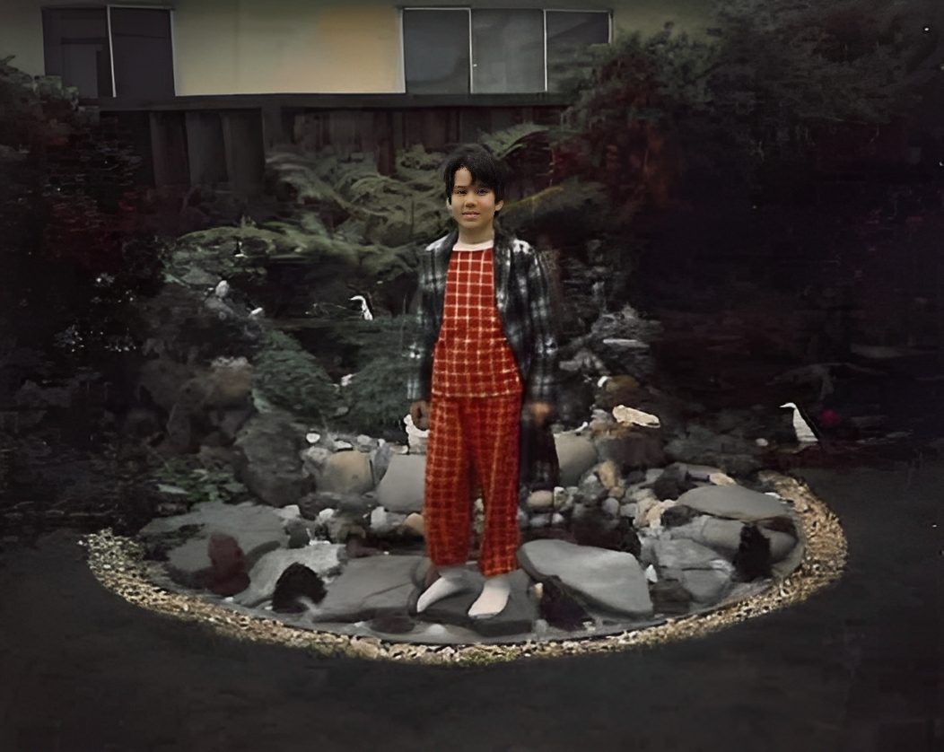 Kid in plaid outfit near pond