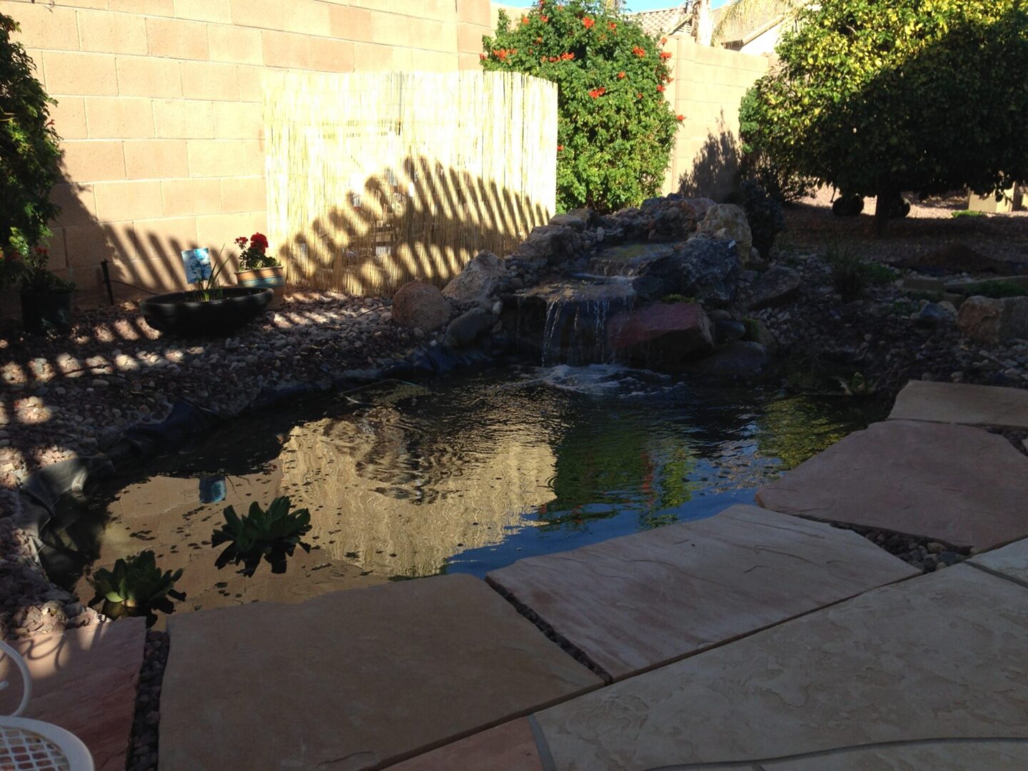 Small waterfall flowing into garden pond