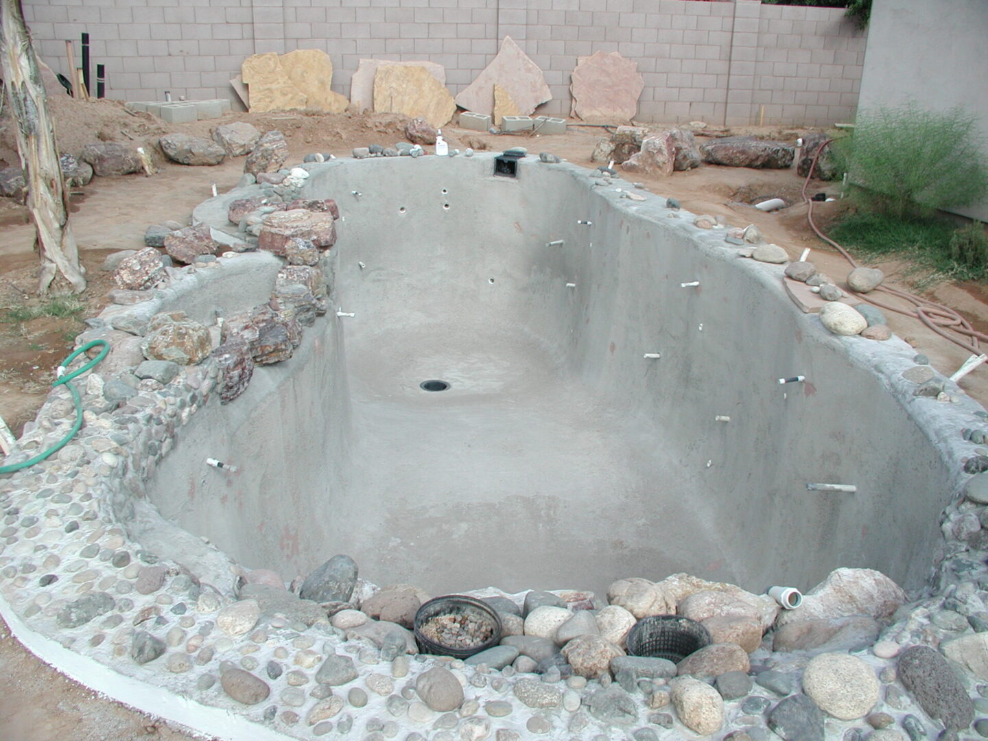 Incomplete pool project surrounded by rocks
