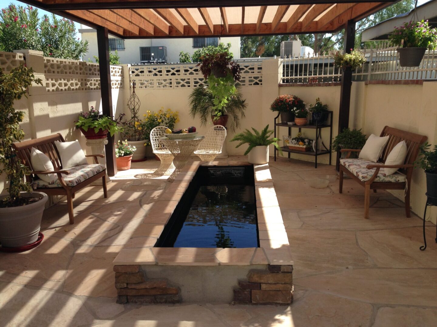 Outdoor seating area with plants and pond